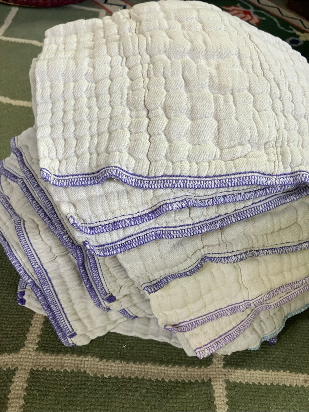 Stack of White Quilted Cloths with Purple Trim